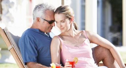 An older man and a younger woman relaxing together outdoors